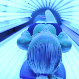 Woman in tanning bed which can eventually cause skin cancer