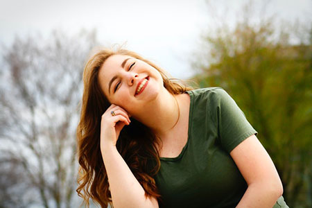 Woman in green in 30s smiling