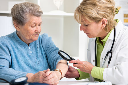 Old lady being examined by a dermatologist