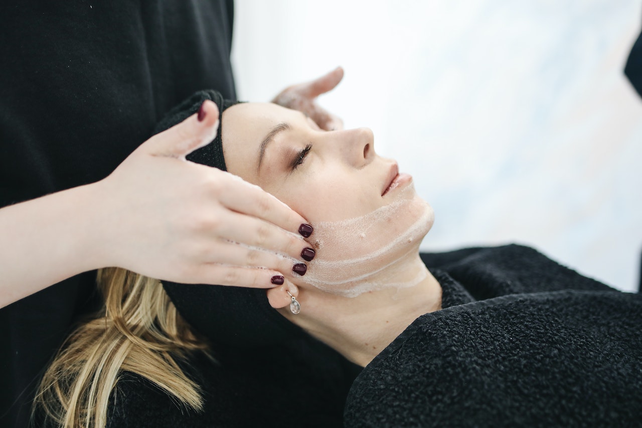 Woman getting skin lightening bleaching treatment from a provider