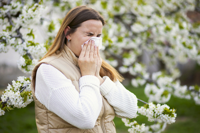 Woman sneezing due to pollen allergy