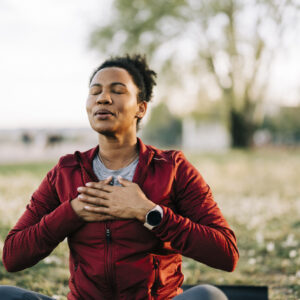 woman holding her hands over her chest and closing her eyes while struggling due to environmental allergies