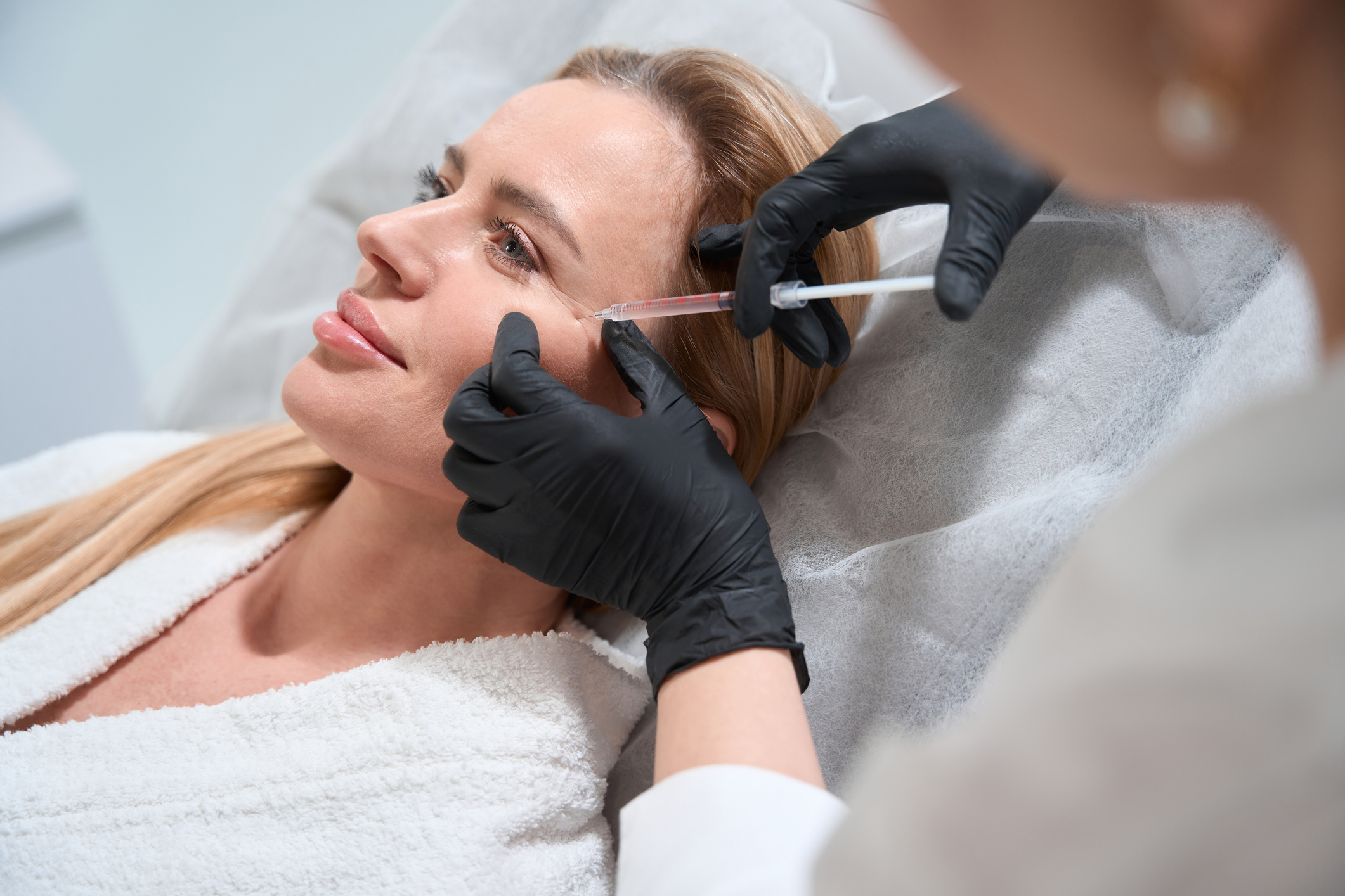 Clous up of a dermatologist injecting botox or filler into a patient