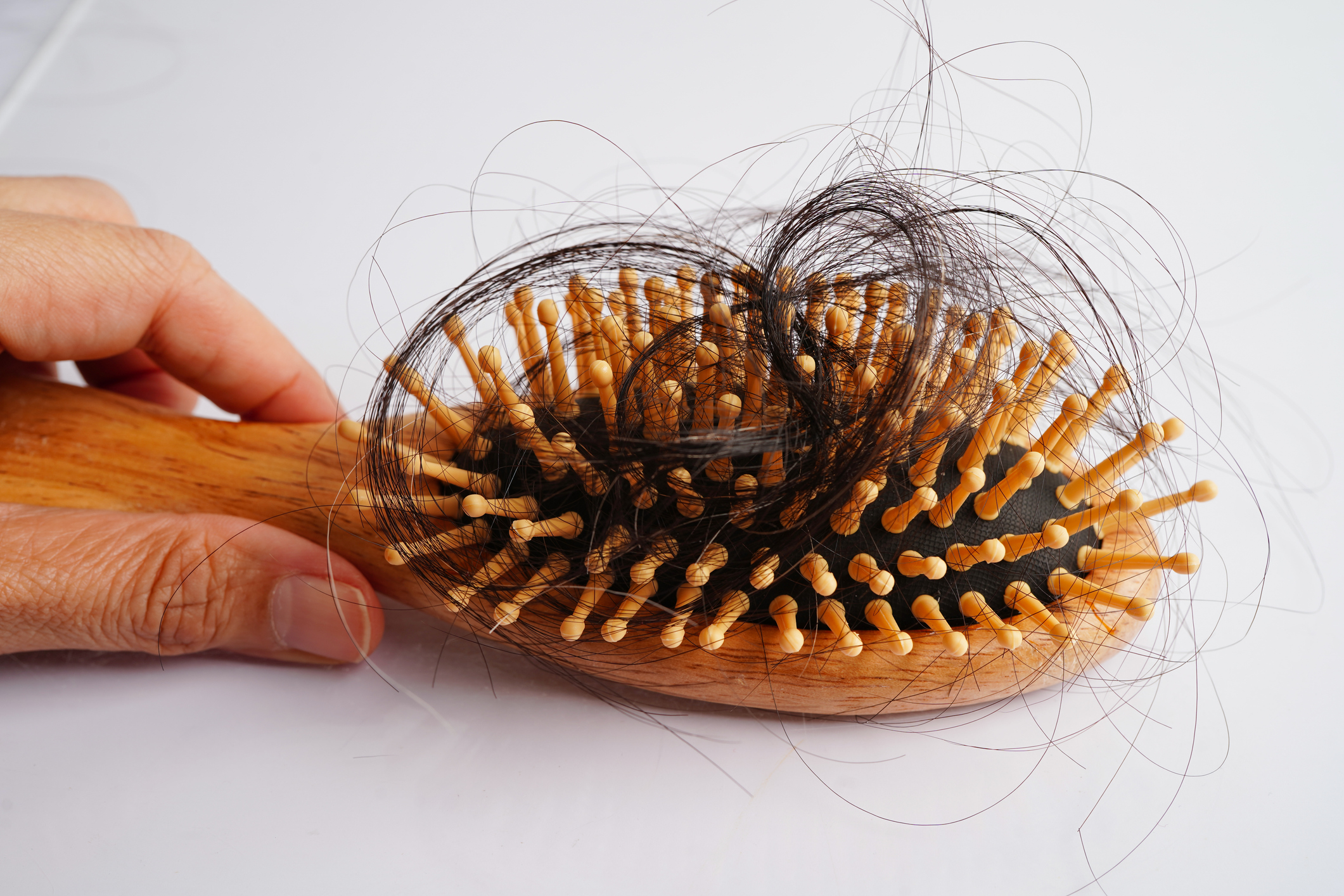 hair brush full on a table representing hair loss