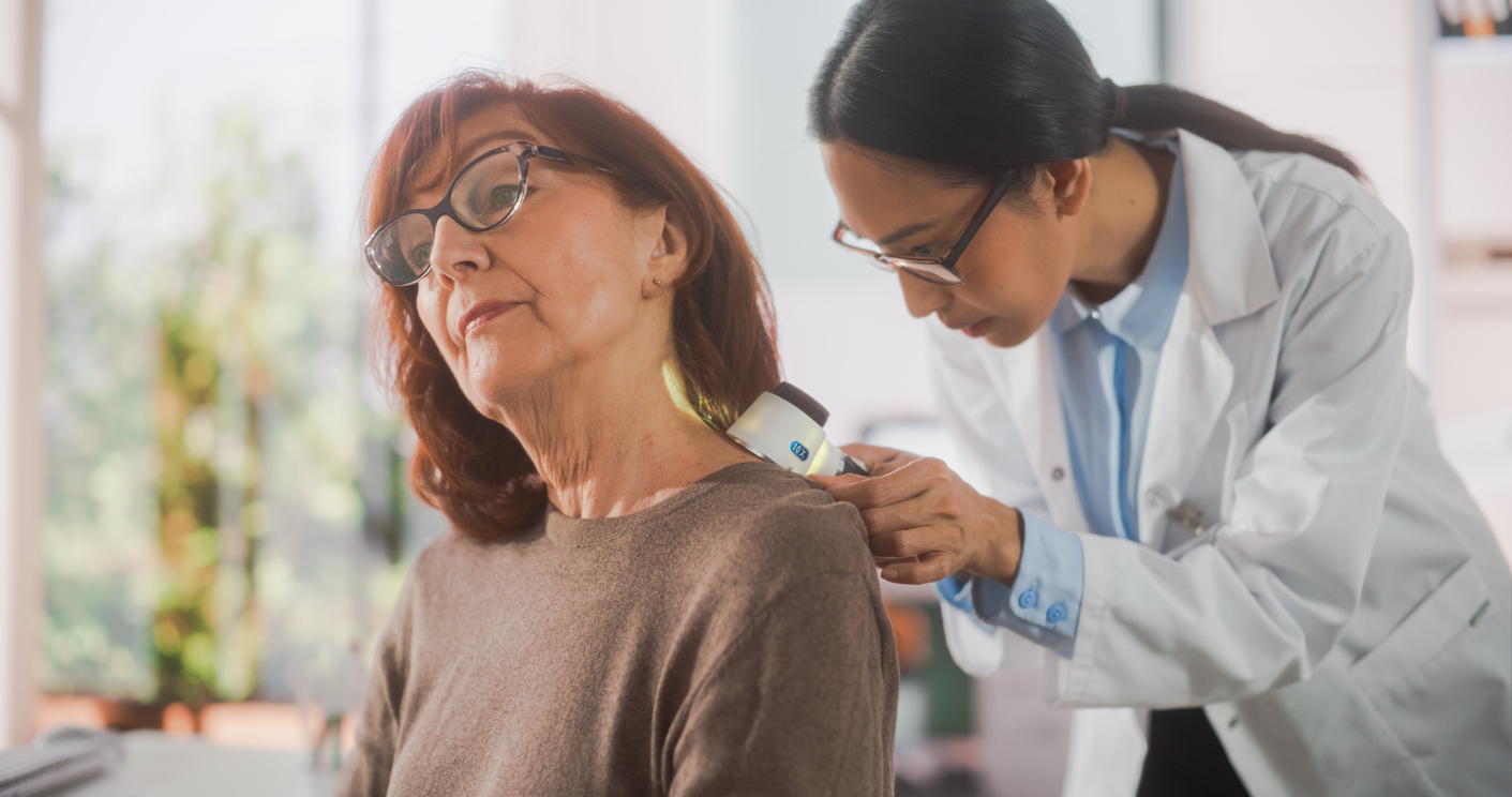 Dermatologist examining the back of a woman's neck