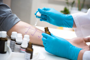 closeup of an allergist provider performing a skin patch allergy test on a patient's forearm