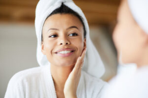 Close up image of a woman touching her clean face after discovering the correlation between nutrition and skin health