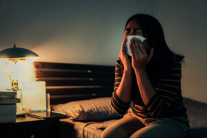 Sad Woman Crying While Sitting On Bed At HoME