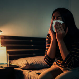 Sad Woman Crying While Sitting On Bed At HoME