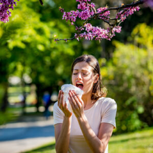 Woman has sneezing. Young woman is having flu and she is sneezing. Sickness, seasonal virus problem concept. Woman being sick having flu sneezing.