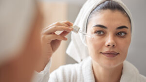 Reflection in a mirror beautiful woman making cosmetic skin care